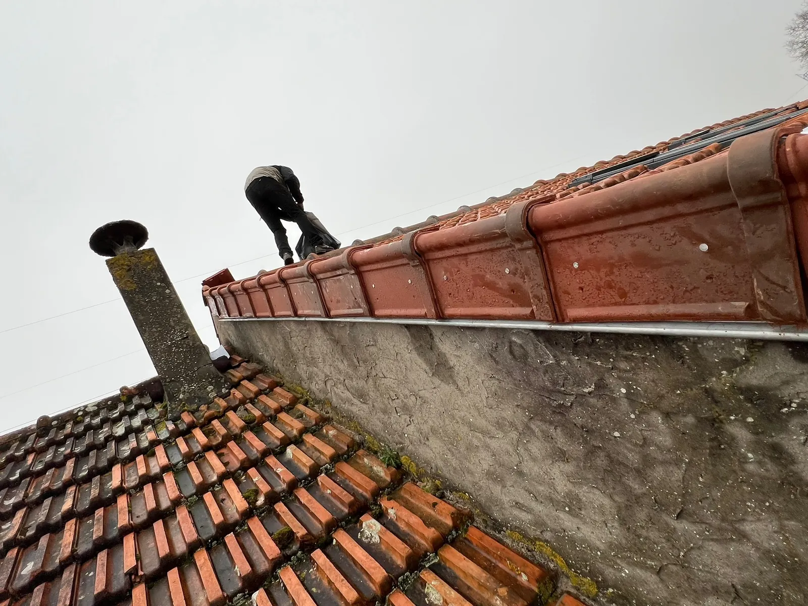Mur pignon protégé par des faîtières en terre cuite après réparation à Auffargis
