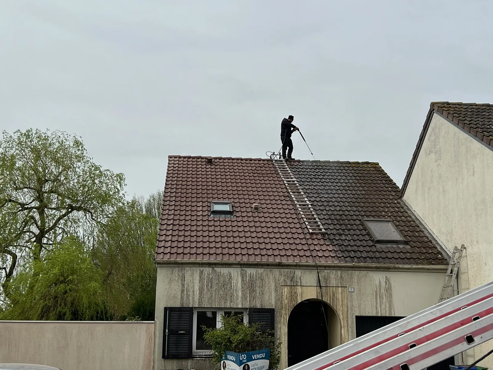 Toiture en tuiles à moitié nettoyée sur une maison de Rambouillet : différence avant et après