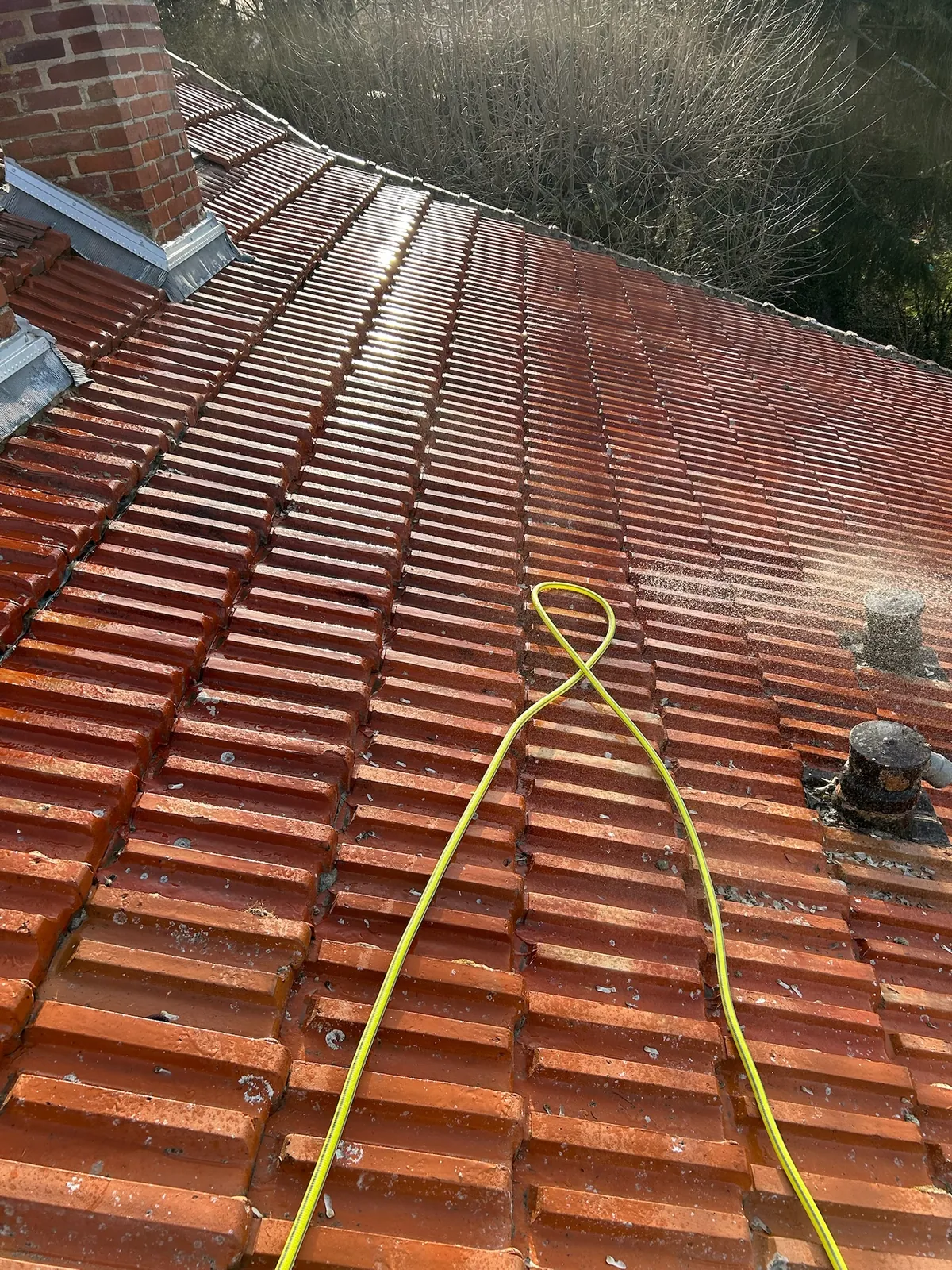 Tuiles en terre cuite rouge après nettoyage sur une toiture de Rambouillet