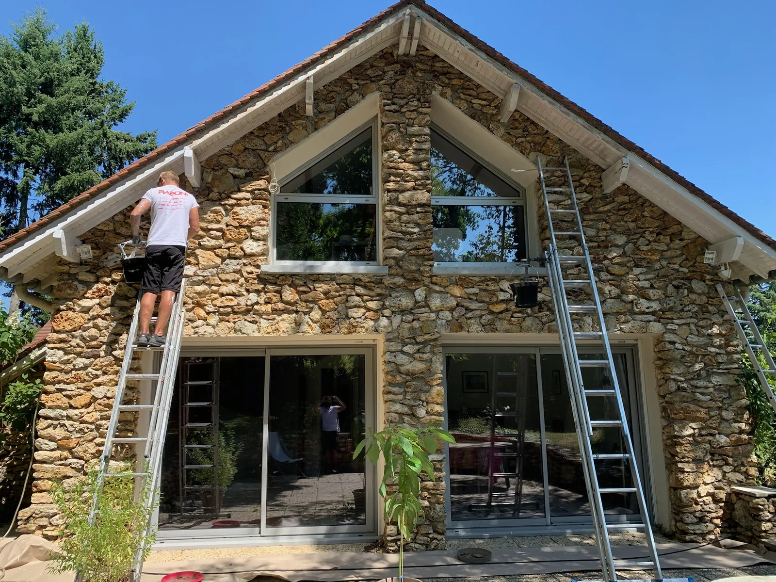 Peinture des voliges et des planches de rive du débord de toit d'une maison en meulière à Dampierre-en-Yvelines