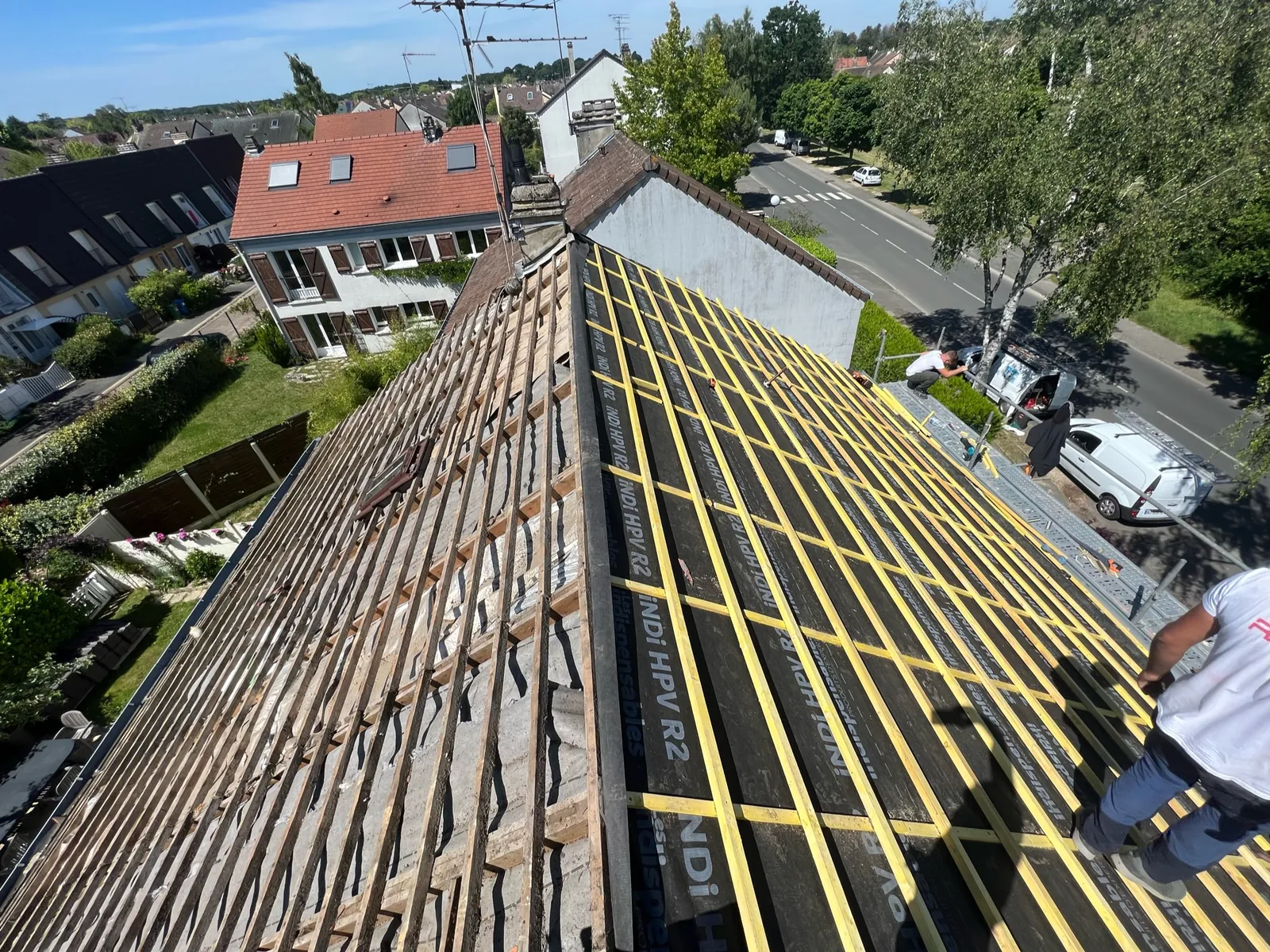 Toiture de pavillon à Rambouillet : ancienne couverture déposée d'un côté, écran et liteaux neufs de l'autre